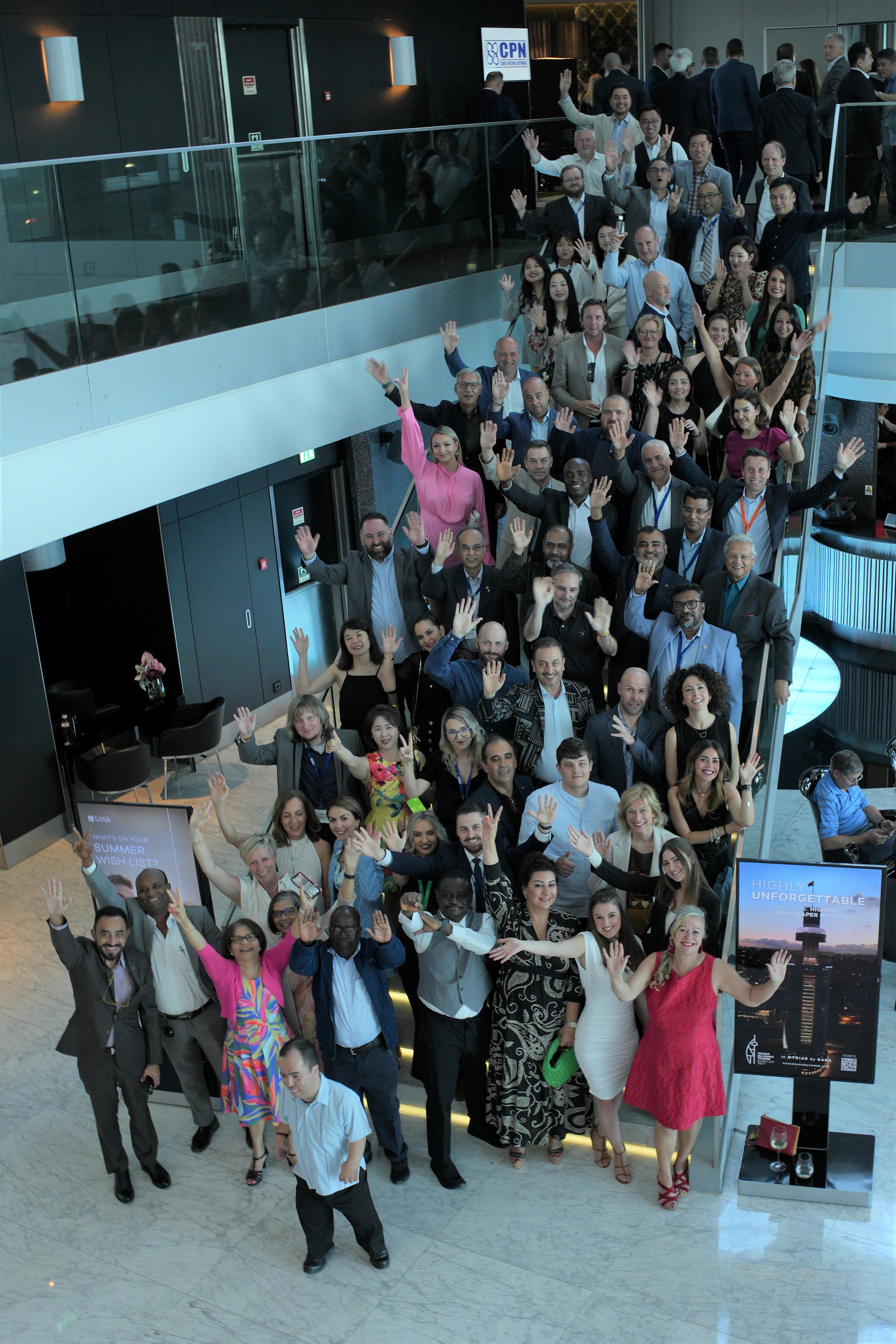 Delegates waving to the camera on a hotel staircase